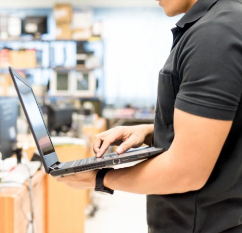 man holding laptop on production floor