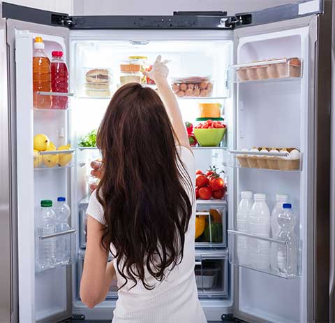 woman putting food into the fridge