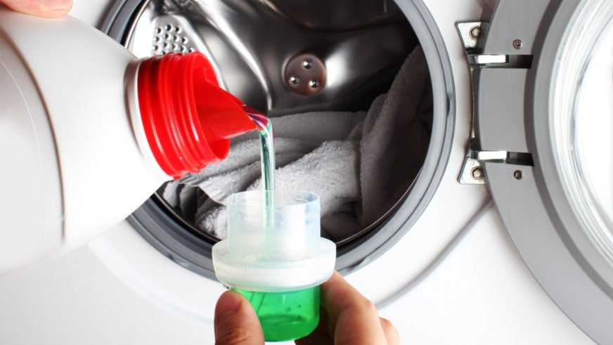 pouring laundry detergent into cup