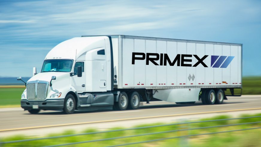 full length view of Primex semi truck driving down the road
