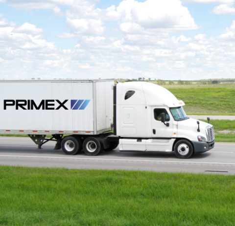 view of primex semi driving down the road cut off halfway