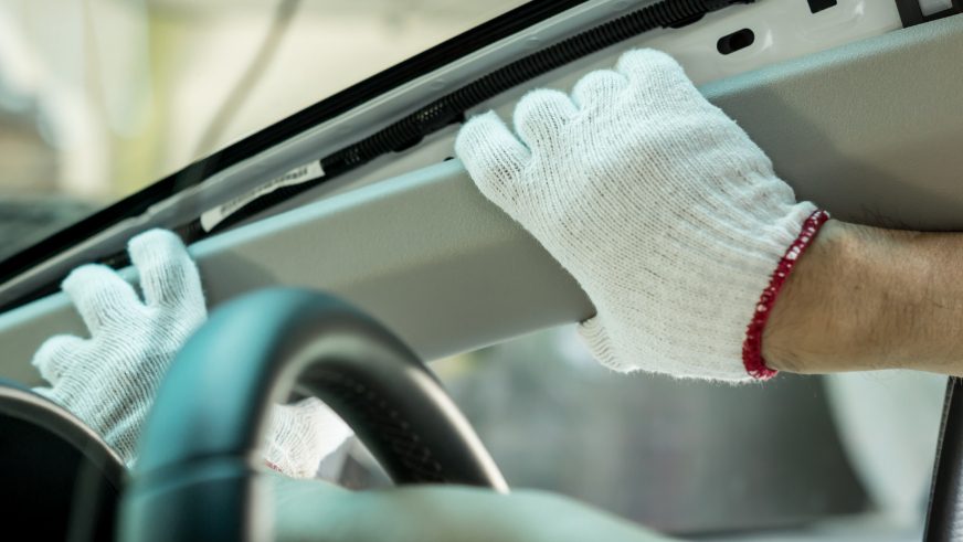 man dismantling the inside of a car plastic lining