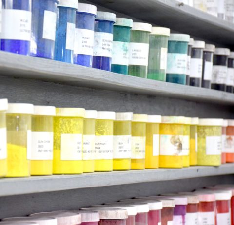 containers of dry dispersion pigments on shelves
