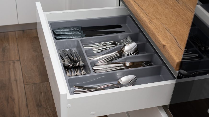 drawer filled with silverware with plastic drawer divider