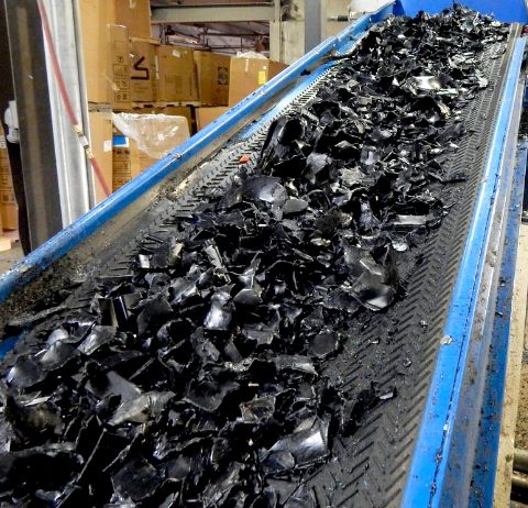 primex conveyor belt with black recycled pieces going down the line